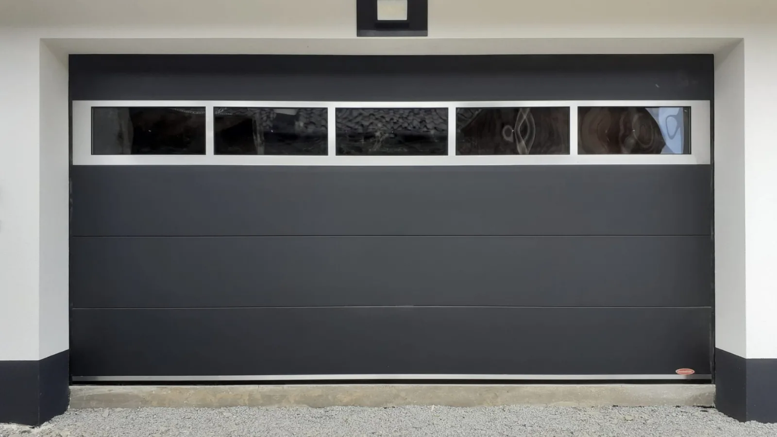 Ușă de garaj cu panouri antracit sandrgrain și vitrat.